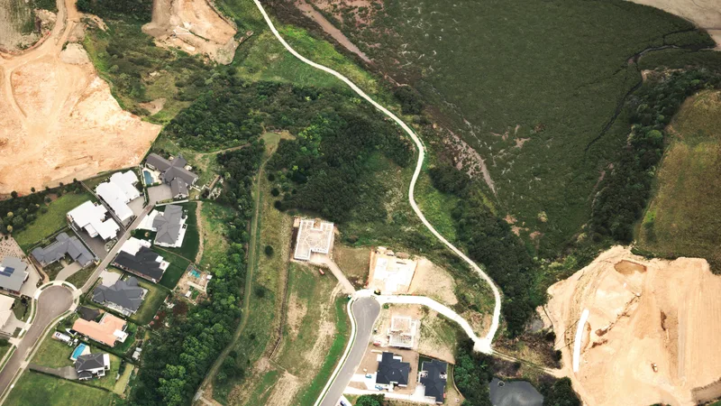 Aerial view of Brisbane suburban housing estate with new homes under construction representing Queensland first home buyer market