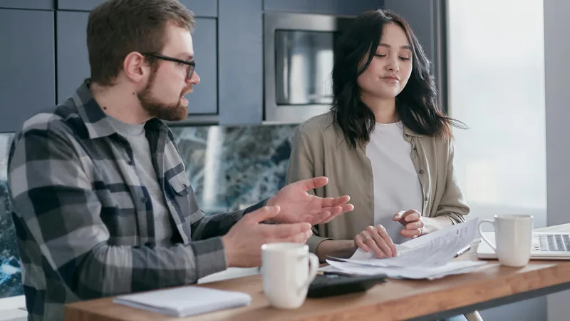 Australian family reviewing health insurance options at kitchen table with laptop and policy documents