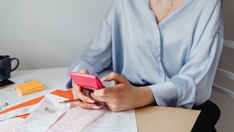 Australian driver comparing car ownership costs and repair quotes with a calculator at a kitchen table