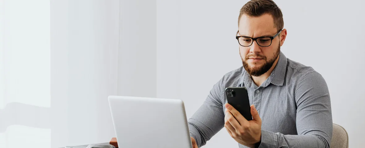 Australian worker checking superannuation balance on phone with payslip on desk showing payday super contribution