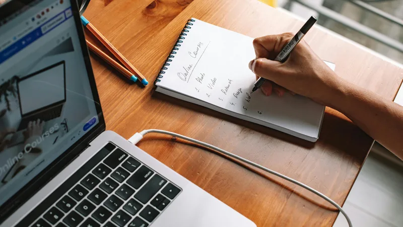 Teacher reviewing professional development course materials and CPD workbook at a home desk in Australia