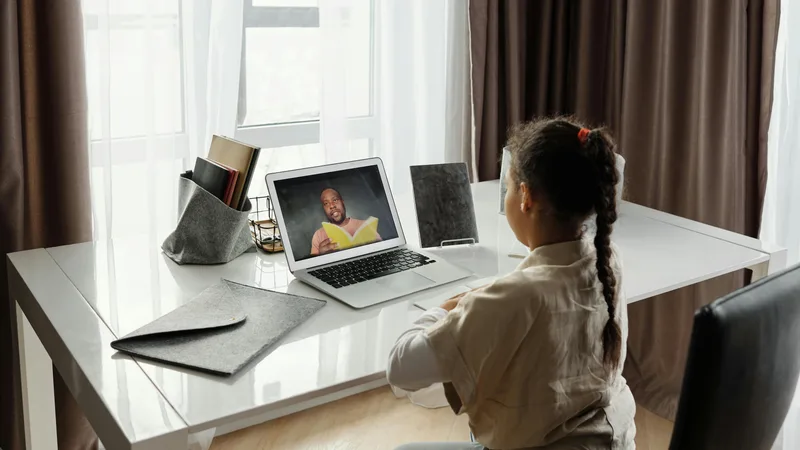 Teacher using a laptop and iPad with Apple Pencil to prepare lesson plans at home in Australia, 2025