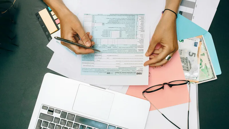Australian working from home at laptop with tax documents